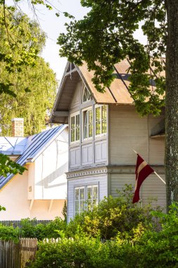 Büyük pencereli ve dalgalı bayraklı güneşli ahşap ev