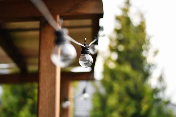 Close up of retro light bulb string for decoration in outdoor patio. Selective focus.