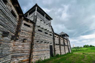 Old wooden fortress in Peresopnytsya, Ukraine, on the background of stormy sky. Wide angle view. clipart