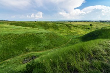 Yeşil tepeleri çimlerle kaplı, nefes kesici vadi manzarası. Mavi gökyüzü arkaplanı. 