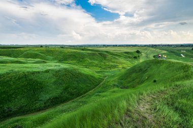 Yeşil tepeleri çimlerle kaplı, nefes kesici vadi manzarası. Mavi gökyüzü arkaplanı. 