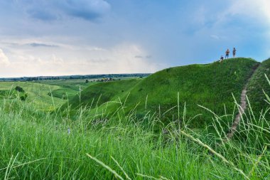 Yeşil tepeleri çimlerle kaplı, nefes kesici vadi manzarası. Mavi gökyüzü arkaplanı. 