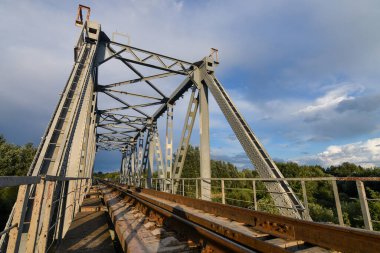 Yazın gün batımında nehrin üzerindeki demiryolu köprüsü..