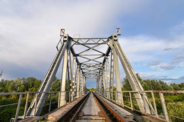Yazın gün batımında nehrin üzerindeki demiryolu köprüsü..