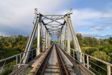 Yazın gün batımında nehrin üzerindeki demiryolu köprüsü..