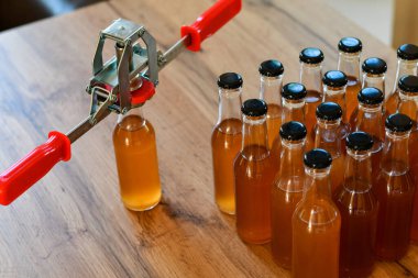 Kahverengi şişelerin arka planında el kaplaması ve ev yapımı içki ya da alkol. Ev yapımı.