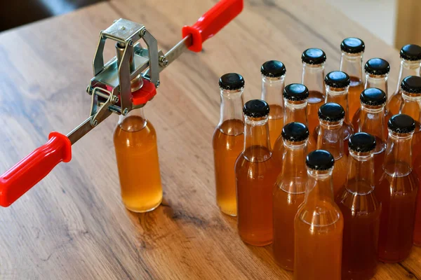 Kahverengi şişelerin arka planında el kaplaması ve ev yapımı içki ya da alkol. Ev yapımı.