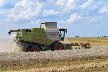 Buğday tarlası ekinleri üzerinde çalışan hasatçıyı birleştirin.