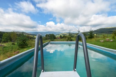 Açık havuzun dağ manzaralı geniş açılı görüntüsü. Seçici odak. 