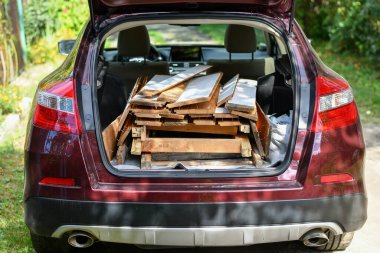 Geri dönüşüm için arabaya yüklenmiş eski tahta ve tahtalar yükleyin