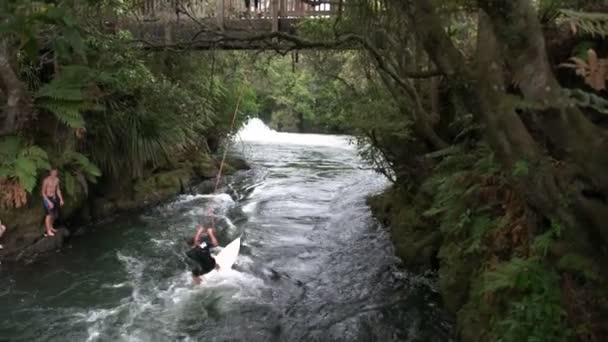ロトルア ニュージーランド 2015 若い男性観光客使用サーフボードとロープ ロトルア ニュージーランド近くカイトゥナ川で楽しい時を過す — ストック動画