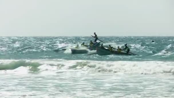 Clef haute contre-jour des bateaux de surf attrapant une vague lors d'une course sur la côte ensoleillée — Video