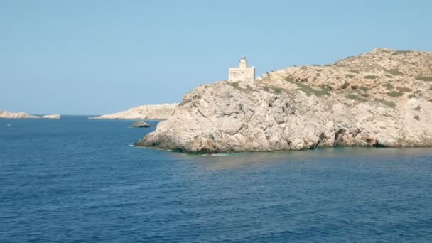 Navegando más allá del faro en el puerto de ormos en la isla de ios — Vídeos de Stock