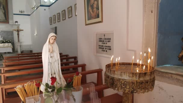 MYKONOS, GRECIA - 13 DE SEPTIEMBRE DE 2016: estatua y velas dentro de la iglesia católica en la plaza Alefkandra en mykonos — Vídeo de stock