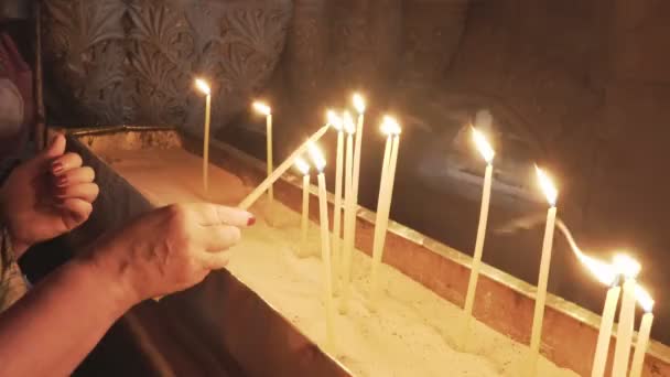 Candles being lit in the church of the holy sepulchre — Stock Video