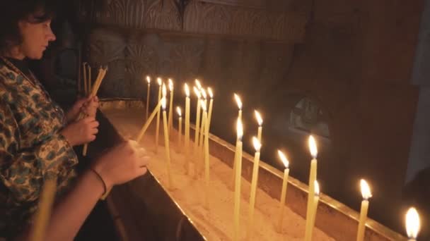 JERUSALEM, ISRAEL-SETEMBRO, 20, 2016: duas mulheres acendem velas na igreja do santo sepulcro — Vídeo de Stock