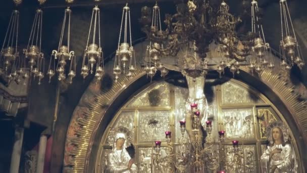 Tilt down shot of the crucifixion site and a kneeling woman praying in the church of the holy sepulchre in jerusalem — Stok Video