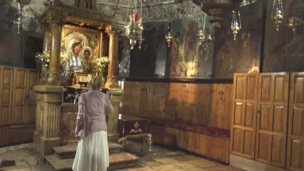 A woman makes the sign of the cross on herself at the tomb of virgin Mary in jer: — стоковое видео