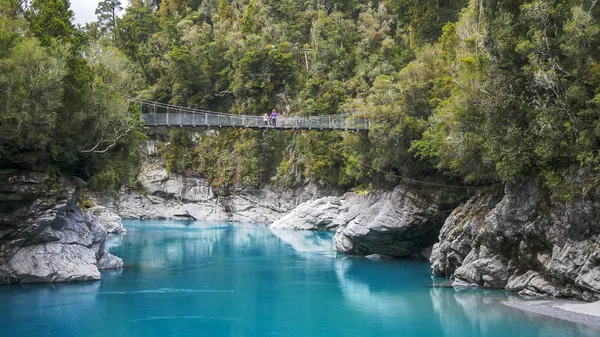 Туристи захоплюються ущелиною з гойдалкового мосту — стокове фото