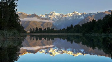 late afternoon shot of mt cook reflected in the waters of lake matheson clipart