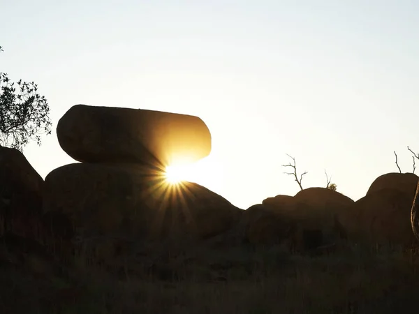 the devils marbles and sunbeams at sunrise in the nt