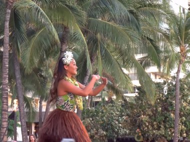 Honolulu, Amerika Birleşik Devletleri - 6 Ağustos 2015: bir etek yeşil giysili bir kadın hula dansçı waikiki beach, hawaii gerçekleştirir.