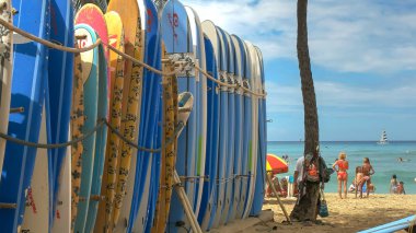 Honolulu, Amerika Birleşik Devletleri - 5 Ağustos 2015: Waikiki Plajı'nda turistler ve bir dizi kiralık sörf tahtası