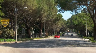 Beverly Hills, Ca, Abd -25 Ağustos 2015: Los Angeles'taki Beverly Hills tabelasını geçen lüks kırmızı spor bir araba