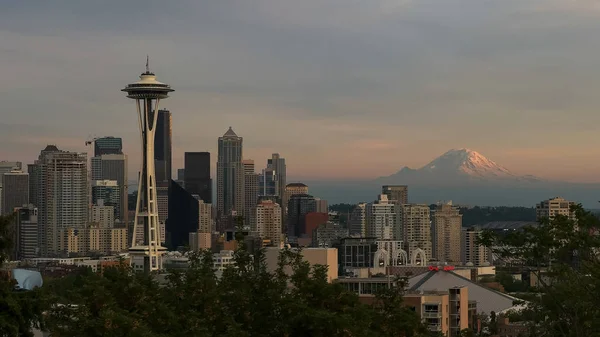 the space needle and mount rainier in seattle at sunset