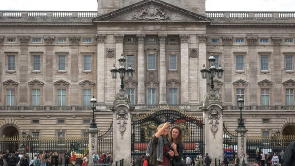 LONDRES, INGLÊS, Reino Unido - SETEMBRO 17, 2015: duas jovens turistas posam para uma foto no Palácio de buckingham, Londres — Fotografia de Stock
