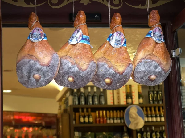 Rome, Italië-30 september 2015: Close-up van de benen van prosciutto Hams in de deuropening van een delicatessen, Rome, — Stockfoto