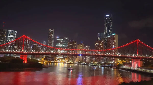 Plano nocturno del puente de la historia en brisbane iluminado con luces rojas —  Fotos de Stock