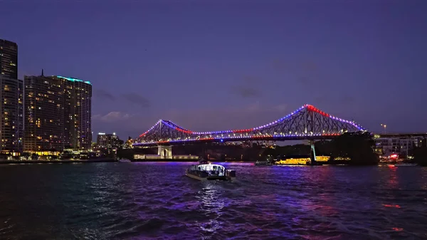 Night time shot of the story bridge and ferry in brisbane, australia as seen from the north bank — Stock Photo, Image