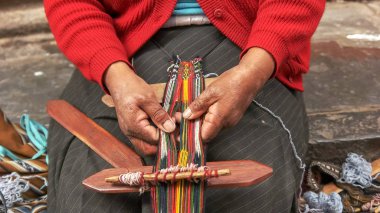 peruvian woman weaving on a street in cusco, peru clipart