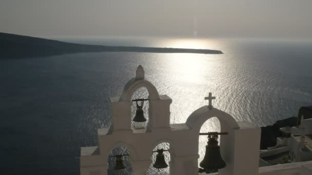 Sol på havet och fyra kyrkklockorna i Oia, Santorini — Stockvideo