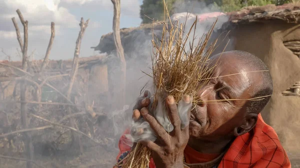 a maasai warrior starts fire the traditional way at a manyatta in kenya