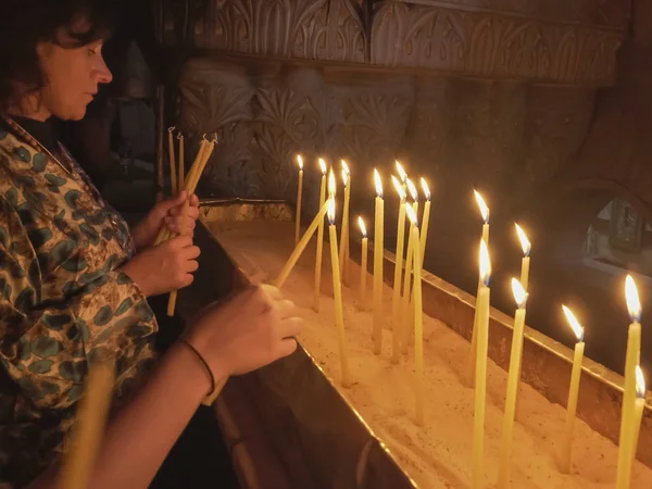 Jerusalem, Israel-september, 20, 2016: två kvinnor tända ljus i kyrkan av den heliga gravens — Stockfoto