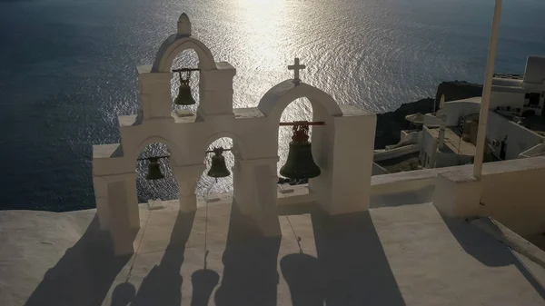 Primer plano de cuatro campanas de la iglesia al atardecer en oia, santorini —  Fotos de Stock