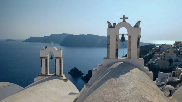 Dos campanas de iglesia en el pueblo de oia en santorini —  Fotos de Stock