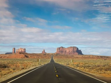 driving on highway 163 on a sunny spring morning at monument valley clipart