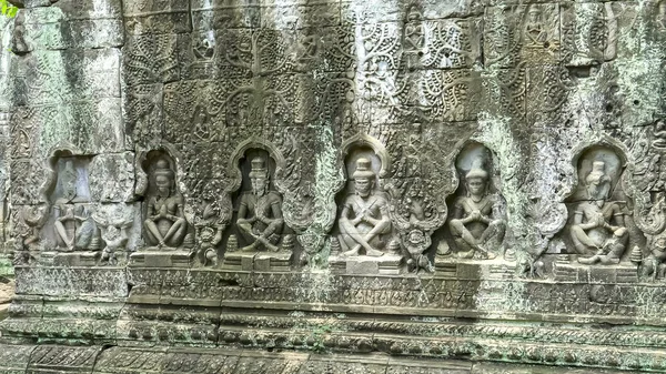 Bajorrelieve tallado de figuras sentadas en el templo preah khan —  Fotos de Stock