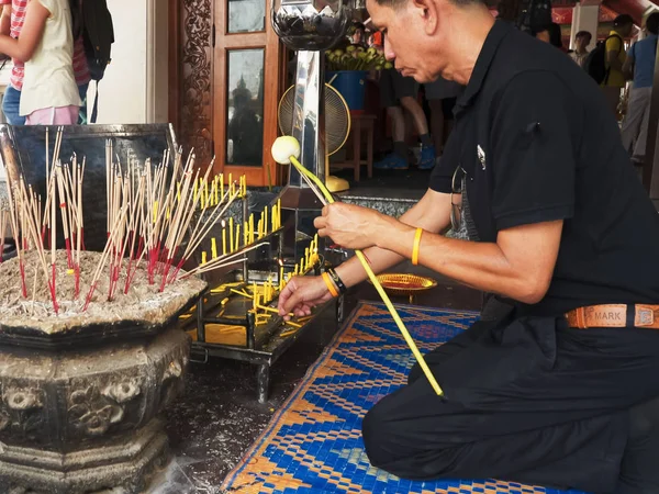 BANGKOK, THAILAND-červen, 21, 2017: Thajský muž zapaluje svíčku v chrámu Wat Pho v Bangkoku — Stock fotografie