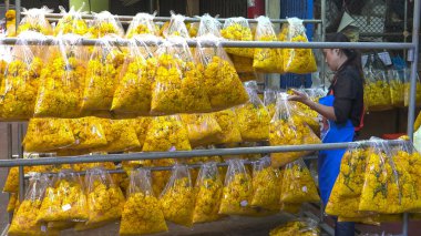 BANGKOK, THAILANDAN - 22 HAZİRAN 2017 Bangkok 'ta çelenkleri sıralayan Taylandlı bir kadının geniş açılı çekimi