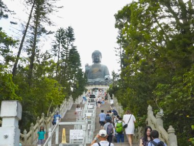 HONG KONG, ÇİN-EYLÜL, 30, 2017: bronz Buda 'ya giden basamakları tırmanan ziyaretçiler