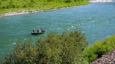 anglers fly fishing from a drift boat on the snake river