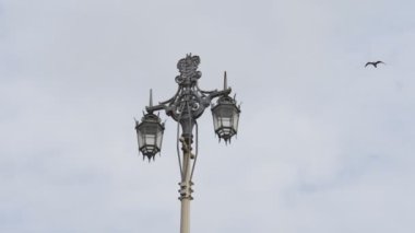 Brighton sahilindeki eski bir sokak lambası ve uçan martıların yavaş çekim klibi.