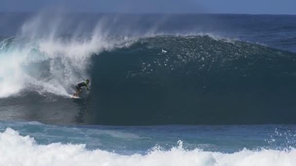 Um tiro em câmera lenta de um surfista sendo filmado por drone recebendo um passeio de tubo em gasoduto — Vídeo de Stock