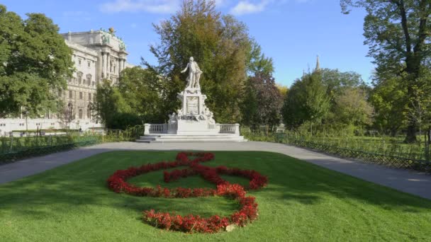 VIENNA, OOSTENRIJK-OKTOBER, 9, 2017: wijd beeld van een mozart standbeeld en tuinen in vienna, Oostenrijk — Stockvideo