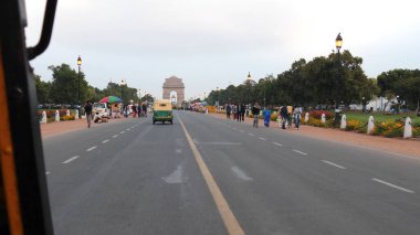 DELHI, INDIA - 14 Mart 2019: Pov, New Delhi 'deki Hindistan Kapısı' na doğru bir tuk tuk 'a binerken vuruldu