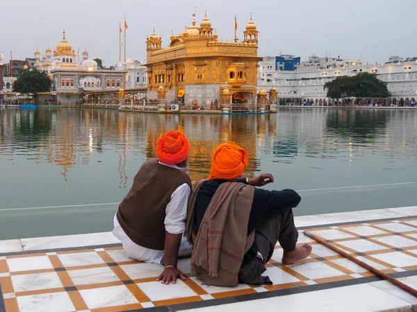 AMRITSAR, INDIA - 18 marca 2019: dwóch sikh mężczyzn siedzących obok basenu złotej świątyni w Amritsarze — Zdjęcie stockowe